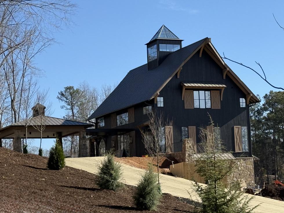 Black barn home clad in charred wood, with cupola and standing seam roof