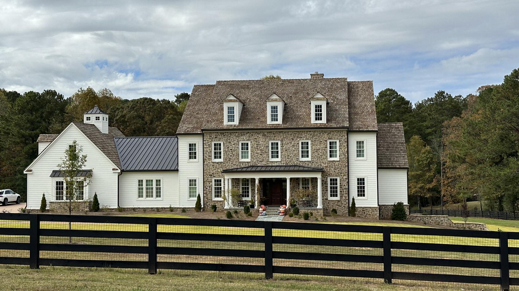 Stone and white lap siding home with painted trim and dormers