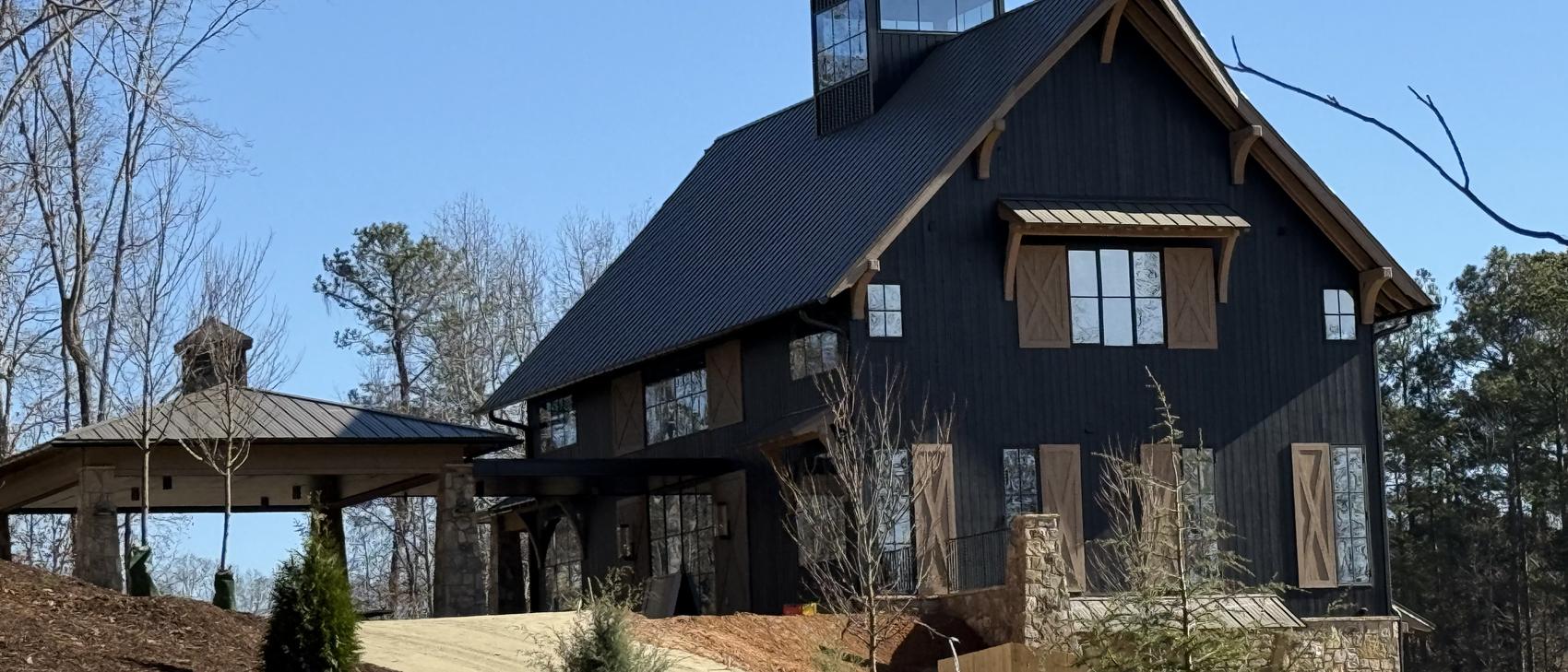 Black barn home clad in charred wood with heavy timber bracing