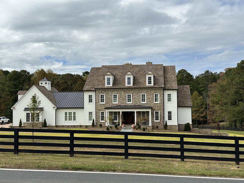 Stone and lap siding colonial with cedar shake roof and standing seam wing